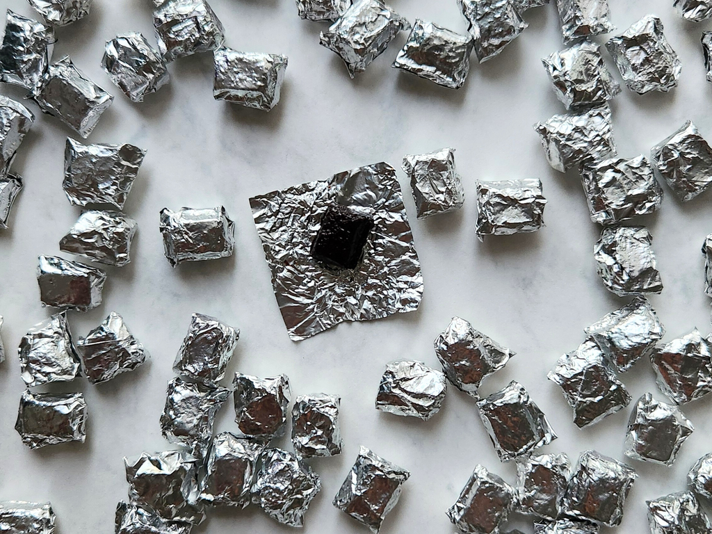 Aluminium foil-wrapped puerh tea resin on a white surface